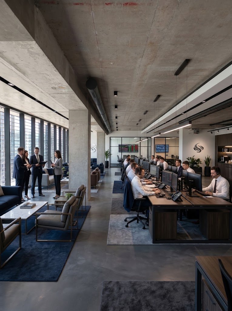 Piso de oficinas habilitado con puestos de trabajo y zona de reuniones informal junto a la fachada